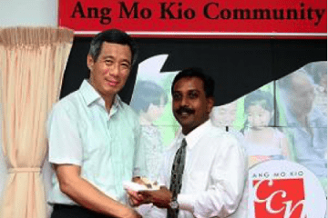 Dr. John Louis receiving the 2005 Comcare Enterprise Fund award from Singapore PM Lee Hsien Loong.