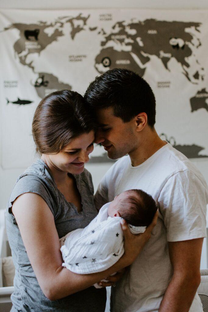 A mother and father in a state of bliss as they hold their newborn baby.