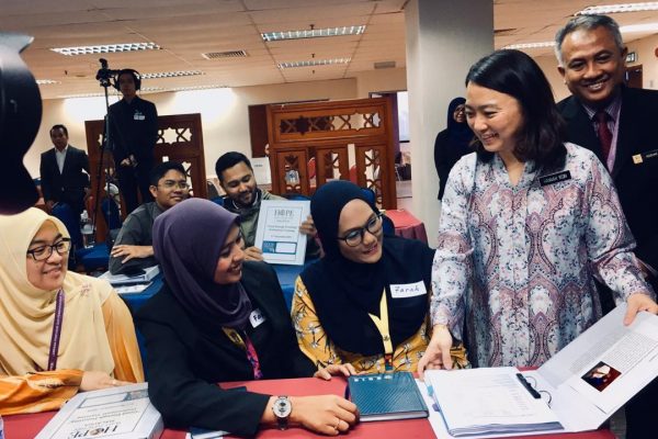 A group of women look over Good Enough Parenting materials at one of the workshops.