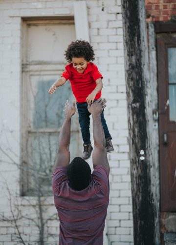 A parent tossing their child in the air.